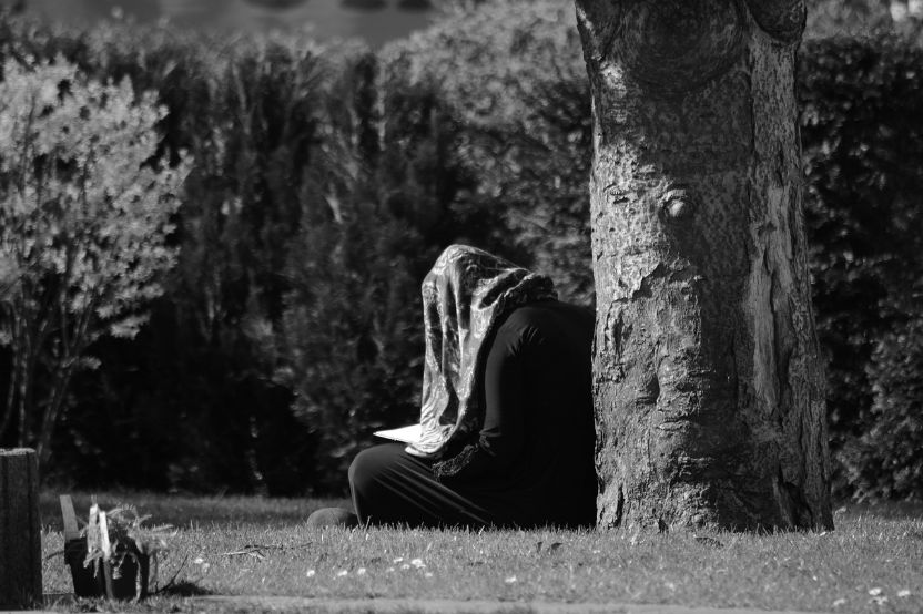 مسلمان خاتون پارک میں قرآن پڑھتے ہوئے
