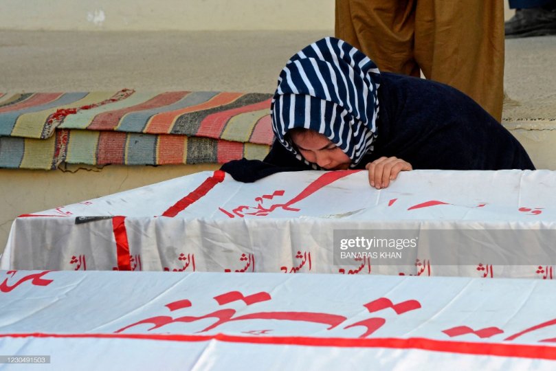 ہزارہ قبیلہ کی ایک غم زدہ خاتون تابوت پر جھکی ہوئی ہے